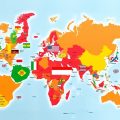 Hartă mondială cu regiuni geopolitice și steaguri diverse.